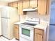 Cozy kitchen featuring light wood cabinets and white appliances at 8386 Sw 105Th Pl, Ocala, FL 34481