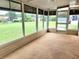 Enclosed sunroom boasts panoramic views of the large yard and outdoor greenery at 8386 Sw 105Th Pl, Ocala, FL 34481