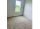 Bright bedroom featuring carpet flooring, a window with a scenic view, and ample natural light at 5543 Siltstone St, Lakeland, FL 33811