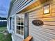 Close-up of the home's exterior showcasing the house number, siding, window, and outdoor lighting at 5790 Cherry Tree Dr, Lakeland, FL 33811