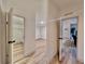 Hallway featuring wood-look flooring, white walls, and open doorways to various rooms at 5790 Cherry Tree Dr, Lakeland, FL 33811