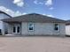 Home's backyard shows concrete-block construction, a rear patio, and well-lit windows at 5722 Cattle Ranch Drive, St Cloud, FL 34771