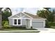 Charming single-story home with a two-car garage, stone accents, and tropical landscaping at 5722 Cattle Ranch Drive, St Cloud, FL 34771