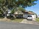 Traditional-style home featuring a brick facade, attached garage, well-maintained lawn, and mature shade trees at 9859 Sw 97Th St, Ocala, FL 34481