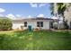 The home has a lush, green backyard with mature trees and a screened-in patio at 10274 Julia Isles Ave, Oxford, FL 34484