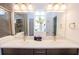 This bathroom has a double sink vanity, neutral colors, and a glass block window for privacy at 10274 Julia Isles Ave, Oxford, FL 34484