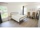 Serene bedroom featuring a comfortable bed, natural light, decor, and light colored wood flooring at 10274 Julia Isles Ave, Oxford, FL 34484