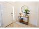 Bright foyer featuring a decor table with a round mirror, plant, and a white front door at 10274 Julia Isles Ave, Oxford, FL 34484