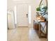 Entryway featuring a decor table with mirror, plant, and a white front door, with a leaner mirror at 10274 Julia Isles Ave, Oxford, FL 34484