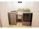 Bright laundry room featuring modern washer and dryer, decorative shelving, and attractive wall decor at 10274 Julia Isles Ave, Oxford, FL 34484