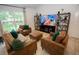 Cozy living room featuring comfortable seating, shelving units and a large window at 10274 Julia Isles Ave, Oxford, FL 34484