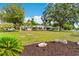 Expansive lawn features an updated single-story house, mature shade trees, and fresh mulch with landscape rocks at 107 Alachua Dr, Winter Haven, FL 33884