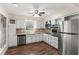 Bright kitchen with stainless steel appliances, white cabinets, wood look floors and a large window at 107 Alachua Dr, Winter Haven, FL 33884