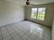 Well-lit bedroom features tile flooring, ample natural light, and a ceiling fan at 299 Cobalt Dr, Kissimmee, FL 34758