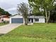 Well-kept single-story home showcases a tidy lawn, light gray siding, and an attached garage with a dark blue door at 299 Cobalt Dr, Kissimmee, FL 34758