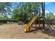 Backyard with a wooden playset, slide, sandbox, and mature landscaping on a sunny day at 4621 Musket Dr, Lakeland, FL 33810