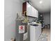 Bright laundry room with storage cabinets, modern washer, and new water heater at 4621 Musket Dr, Lakeland, FL 33810