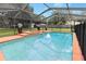 Screened-in pool with a spa, surrounded by lush landscaping and a concrete deck, perfect for relaxation at 4621 Musket Dr, Lakeland, FL 33810