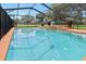 Sparkling swimming pool inside screen enclosure features spa and concrete pool deck at 4621 Musket Dr, Lakeland, FL 33810