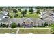 Aerial view of a low-rise condo community with lush landscaping, mature trees, lake and ample parking at 523 Club Cir, Lakeshore, FL 33854