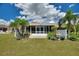 Charming backyard featuring a white fence, lush landscaping, and a screened lanai at 523 Club Cir, Lakeshore, FL 33854