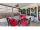 Relaxing screened patio featuring a ceiling fan, tv, and a table with six red cushioned chairs at 523 Club Cir, Lakeshore, FL 33854