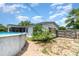 Backyard featuring a pool, greenery, partial fencing, and the home's exterior at 811 Casselberry Dr, Lake Wales, FL 33853