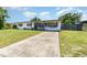 Inviting home showcasing a long driveway and a neat front yard with a picket fence at 811 Casselberry Dr, Lake Wales, FL 33853