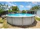 Above-ground pool with a deck, surrounded by a yard and partial fencing at 811 Casselberry Dr, Lake Wales, FL 33853