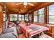 Bright sunroom with wood paneling, tile floors, and a dining area overlooking the backyard at 811 Casselberry Dr, Lake Wales, FL 33853