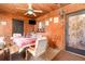 Cozy sunroom featuring wood paneling, a ceiling fan, and a dining table set for a meal at 811 Casselberry Dr, Lake Wales, FL 33853
