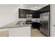 Kitchen featuring stainless steel appliances, granite countertops and sleek dark cabinets at 1183 Honey Blossom Dr, Orlando, FL 32824