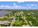 Wide aerial view of a neighborhood near a body of water featuring lush green foliage and buildings at 1440 12Th St, Clermont, FL 34711