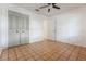 Clean bedroom with tan tile floors, closet space, and a ceiling fan at 1440 12Th St, Clermont, FL 34711