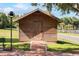 Rustic log cabin with a brick walkway, sitting on a grassy lawn under a clear blue sky at 1440 12Th St, Clermont, FL 34711