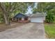 Charming single-story home with a driveway and a two-car garage and mature trees at 1440 12Th St, Clermont, FL 34711