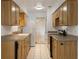 Galley style Kitchen with wooden cabinetry, white appliances, and tile flooring at 1440 12Th St, Clermont, FL 34711