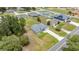 A wide shot of a gray, one-story home, showcasing its surrounding neighborhood and lush trees at 231 Marion Oaks Trl, Ocala, FL 34473