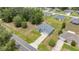A serene aerial perspective of a charming gray, one-story home with lush trees and blue skies above at 231 Marion Oaks Trl, Ocala, FL 34473