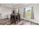Modern dining room with dark wood table, wood-look flooring, and bright windows providing natural light at 231 Marion Oaks Trl, Ocala, FL 34473