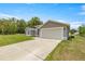 A beautiful one-story home showcasing lush green grass, complemented by a concrete driveway at 231 Marion Oaks Trl, Ocala, FL 34473