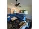Cozy living room featuring a spacious blue sectional sofa, ceiling fan, and unique area rug at 663 Jamaica Cir, Lakeland, FL 33803