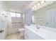 Bright bathroom features a tub with shower, a vanity, and a large mirror at 8851 Sw 116Th Street Rd, Ocala, FL 34481