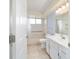 Bright bathroom features a tub with shower, a vanity, and a large mirror at 8851 Sw 116Th Street Rd, Ocala, FL 34481