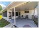 Covered outdoor patio featuring seating, tile flooring, and access to the backyard at 8851 Sw 116Th Street Rd, Ocala, FL 34481
