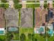 Aerial view of homes with private pools, lush landscaping, and well-maintained lawns in a quiet neighborhood at 1138 Fountain Coin Loop, Orlando, FL 32828