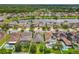 Aerial view featuring houses with pools and solar panels, backing onto a scenic lake in a suburban neighborhood at 1138 Fountain Coin Loop, Orlando, FL 32828