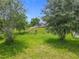 Expansive backyard with a gazebo, lush grass, mature trees, and a gentle slope at 1138 Fountain Coin Loop, Orlando, FL 32828