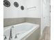 Bright bathroom with a soaking tub, stylish fixtures, and tiled walls at 1138 Fountain Coin Loop, Orlando, FL 32828
