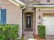 Close-up of a home's front entrance featuring a decorative glass door, brick pathway, and manicured landscaping at 1138 Fountain Coin Loop, Orlando, FL 32828